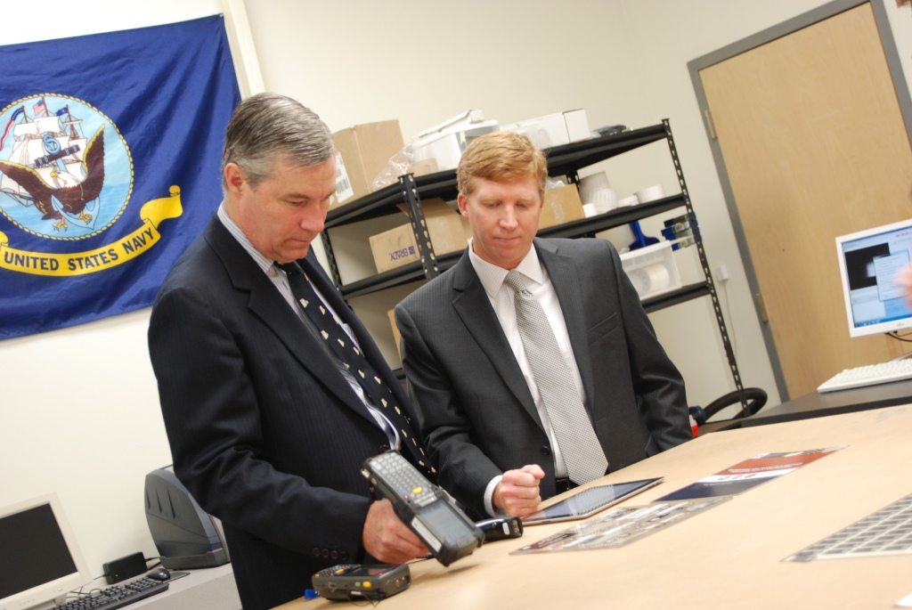 Senator Whitehouse tests out some of the technology at A2B Tracking Solutions in Portsmouth as Tim Collins, VP of Finance & Operations, looks on.